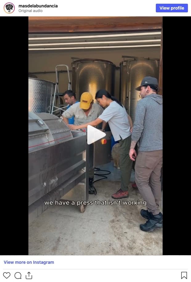The winery team gathered around a pneumatic grape press that isn't working